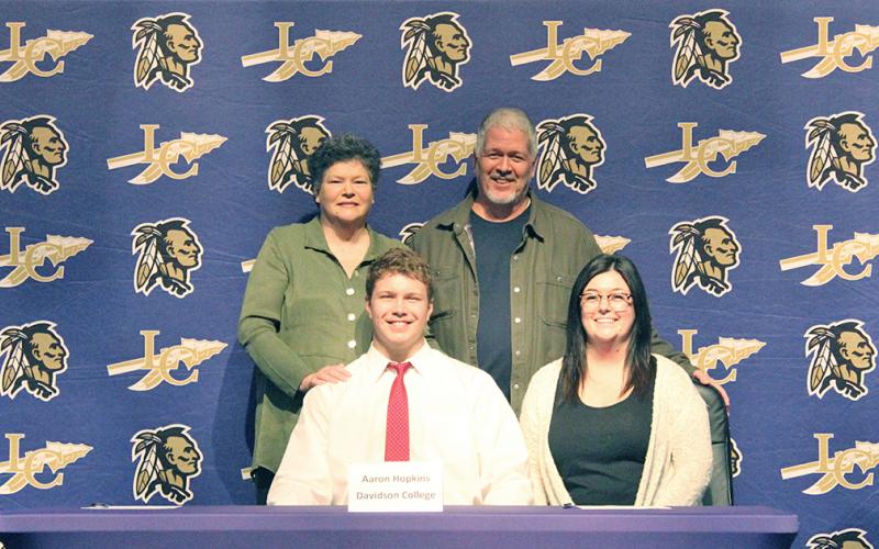 LCHS football player Aaron Hopkins celebrates another four years of football with his mother (back left) Sally Hopkins, his father (back right) Michael Hopkins and his sister (front right) Kelsey Hopkins during a signing ceremony held at the LCHS auditorium recently.