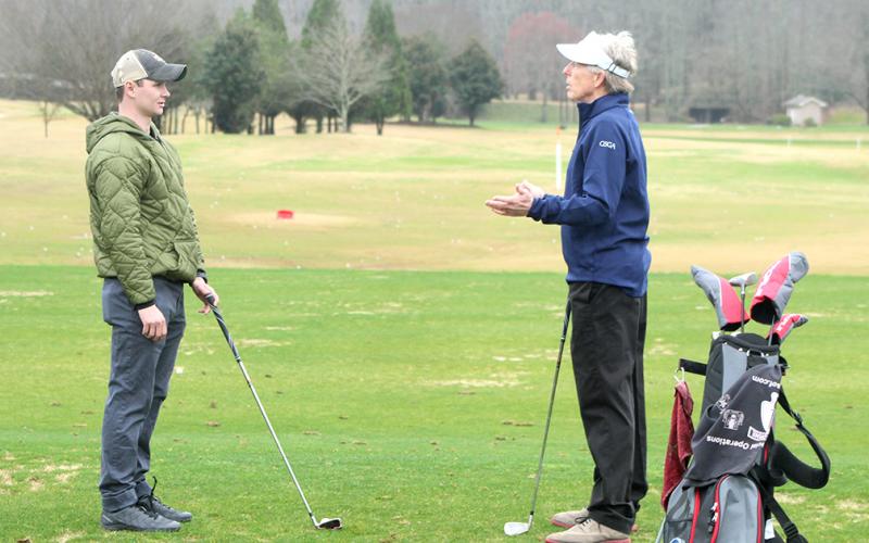 Adaptive Golf Program participant Chris Marshall receives advice on how to improve his swing from golf enthusiast and program volunteer Ken Taylor.