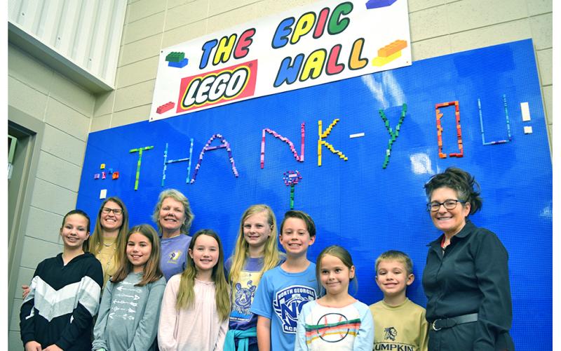 The Epic LEGO Wall received at equally epic dedication at Lumpkin County Elementary School with a ceremony that included, from left, Ally Bicknell, Principal Stacie Gerrells, Charlotte Sessions, School Board Member Lynn Sylvester, Cecilia Woody, Lily Hornbeck, Witt Windham, Avery Caldwell, Maddox Cagle and Media Specialist Kim Jones.