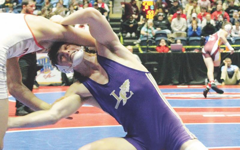 Lumpkin wrestler Sam Irwin takes a shot on his opponent’s leg in the finals match of the GHSA State Wrestling Championship this past season.