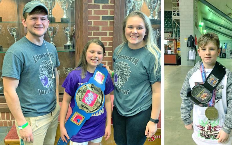LEFT: Caroline Cunningham celebrates her State Championship title with Lumpkin County Youth Wrestling Club coach Tristin Duckworth and her wrestling idol Kaylee Seabolt.  RIGHT: Caleb Yorkey shows off his State Champion belt and medal after an overtime win in the finals. Yorkey became the first USA wrestling champion for Lumpkin County in years.