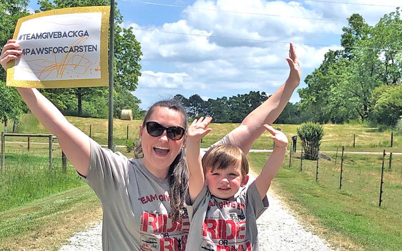Team Give Back member Mallory Wilkins and her son Bo finish up the virtual fundraiser for Carsten Ussery.