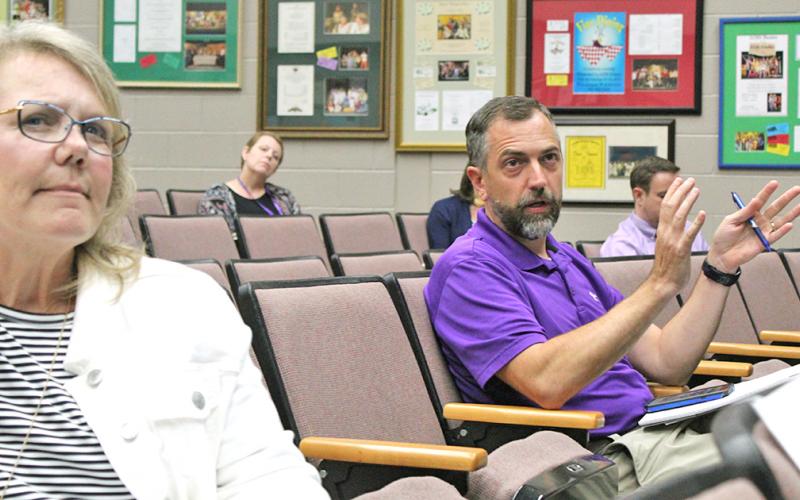 Lumpkin County School Board members Lynn Sylvester and Craig Poore ask questions about the plan to restart school at Monday's meeting.