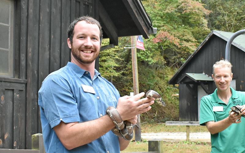 Environmental Education Programs Coordinator Adam Rolwes holds an Eastern King Snake while Center Director David Weber holds an Eastern Box Turtle, which are some of the reptiles that visitors can interact with and learn about.