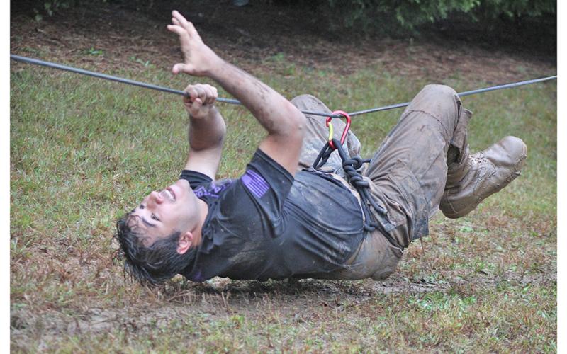 Gabriel Chaves Lima pulls himself across, suspended on a rope in an event called One-rope bridge, where the team had to secure a rope between two poles and get each team member across from start to finish as quickly as possible.