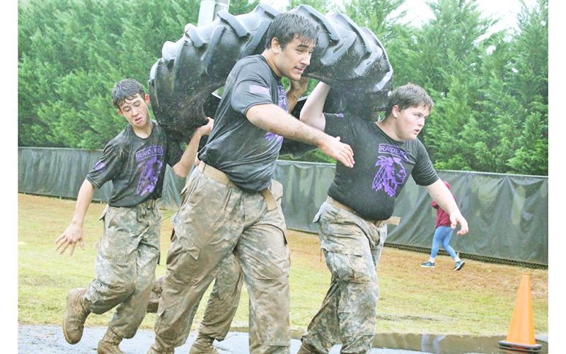 Pictured from left: Ian Daniel, Gabriel Chaves Lima and Jacob Connell team up to carry a heavy, oversized tire as a part of a team race that starts with a humvee pull.