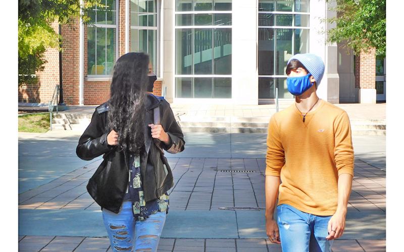 Michaela Follett and Chris Potter mask up and walk to class at the University of North Georgia. The local students weren’t  pleased to hear that their Spring Break has been cancelled for the year.