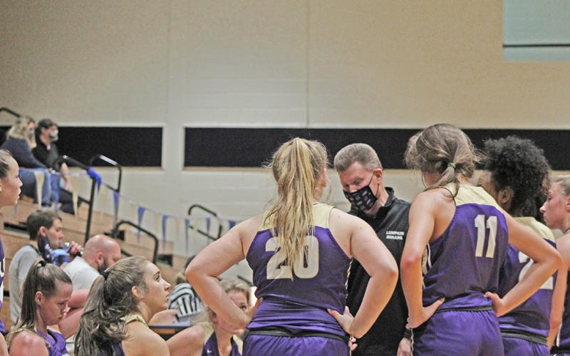Head basketball coach David Dowse huddles with his team during a timeout in Lumpkin County’s 99-20 win over West Hall.