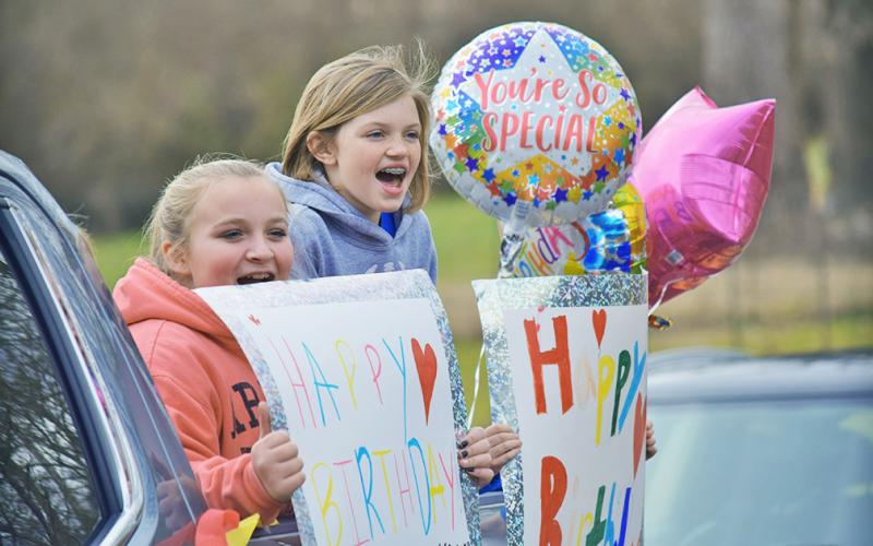Keeley Carpenter, left, and Alivia McBrayer were ready for Miss Helen Kitchen’s party with their own birthday signs.