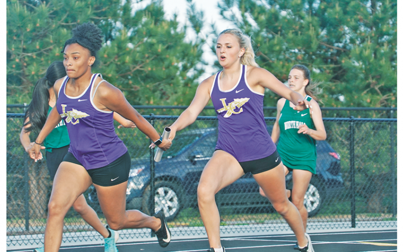 Returning state finalists in the girls 4x100, Kaylee Caldwell (right) hands off to Aniya Persaud smoothly. The runners finished second in the relay, inching to within a second of Cherokee Bluff, who has just edged them out all season long.
