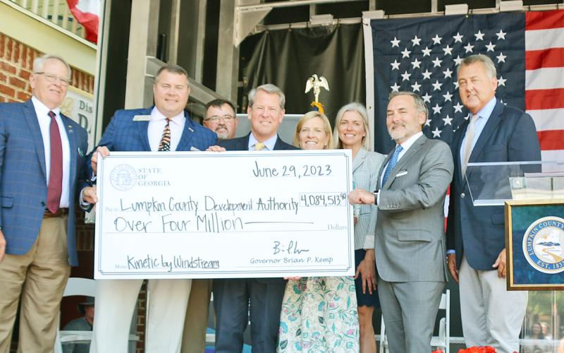 Officials hold up a check representing over four million dollars in state grant funding for broadband internet expansion in Lumpkin County. Pictured (from left) are Development Authority Board Chairman Henry Davis, Representative Will Wade, Board of Commissioners Chairman Chris Dockery, Governor Brian Kemp, First Lady Marty Kemp, Development Authority Director Rebecca Mincey, Windstream CEO Tony Thomas and Senator Steve Gooch.