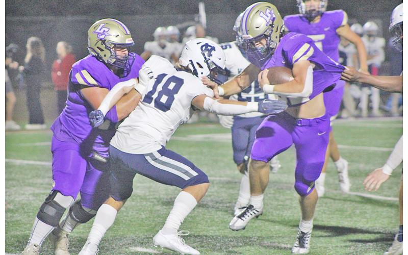 Mason Sullens powers his way downfield as Lane McColeman lays down a block during Lumpkin’s thrilling win over region rival White County.