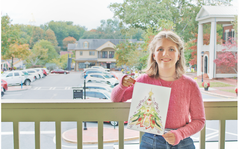 Home school student Amelia Taylor shows off her winning Christmas T-shirt design on the balcony of the Visitors Center in downtown Dahlonega.