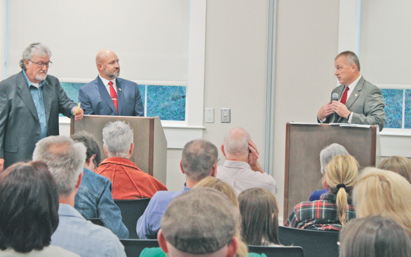 Incumbent Sheriff Stacy Jarrard (right) addresses challenger Matt Cook during last week’s candidate forum as moderator Roger Smith (far left) glances at his notes.