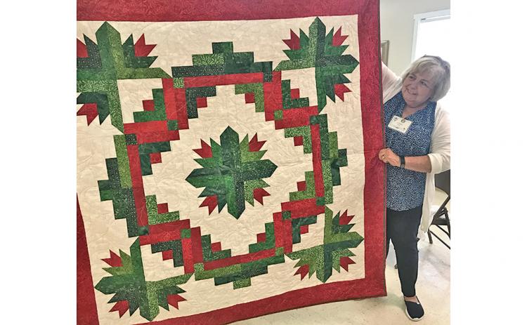 Lynda Duke stands beside the Christmas quilt that will be raffled off Friday, July 26 at The Common Thread. The raffle is part of the shop’s Christmas in July Quilt Show, free and open to the public. Raffle tickets are $5 and proceeds go to support the Dahlonega Valor Quilters, who provide quilts to Lumpkin County’s veterans as a thank you for their service.
