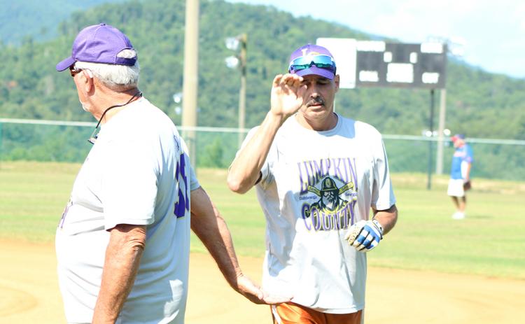 Jimmy “Four Quarters” Dollar gives “Hammering” Harvey Schmedlapp a high-five after Schmedlapp belted a solo home run over the centerfield fence during the Miners’ league doubleheader against the Lake Keowee Kings.