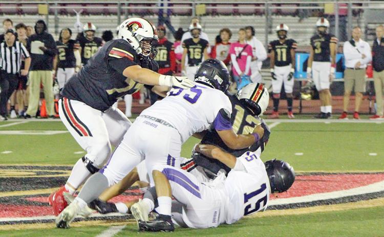 Joseph Allison and Trey Wilkes converge on GAC’s quarterback for a sack during the Indians’ loss to the Spartans.