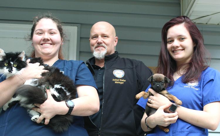 Lumpkin County Animal Shelter staff workers are, from left, Aaron Taylor, holding Slim, Wayne Marshall and Savana Scheidt, holding Pup.
