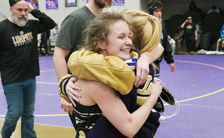 Lumpkin wrestler Chloe Carver meets her sister Kylie with a big hug after clinching a berth at the State tournament. Carver, a senior, is making her long-awaited first appearance at the State tournament after injury held her out last year.