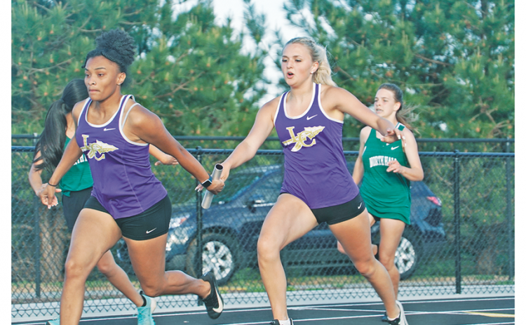 Returning state finalists in the girls 4x100, Kaylee Caldwell (right) hands off to Aniya Persaud smoothly. The runners finished second in the relay, inching to within a second of Cherokee Bluff, who has just edged them out all season long.