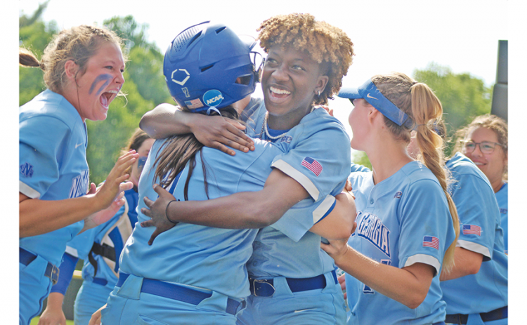 After being held in check for most of the day, the Nighthawks exploded, first on the field, then in celebration as Mariah Wicker (right) hugs teammate Madison Simmons after her teammate scored from first to give UNG its first lead of the day in extra innings of the season-determining game. Now the squad is headed to Denver for the NCAA Division II National Championship.