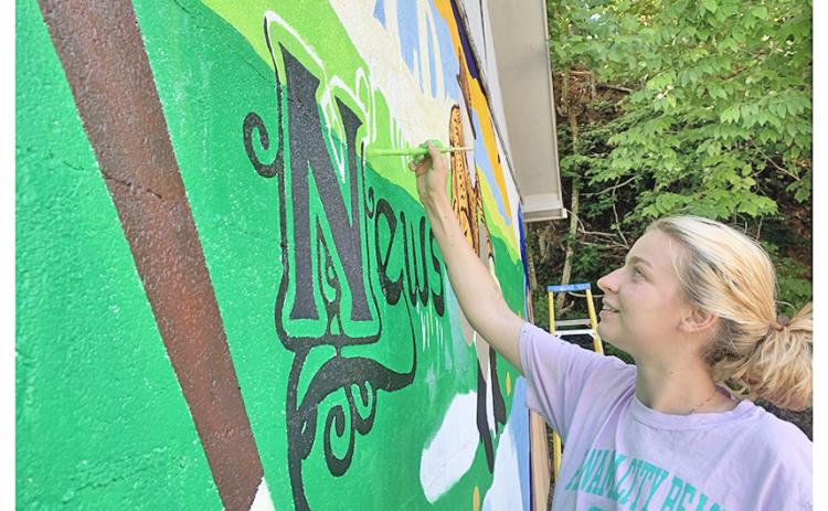 Whitney Little works diligently on the new mural that now decorates the side of The Nugget office.