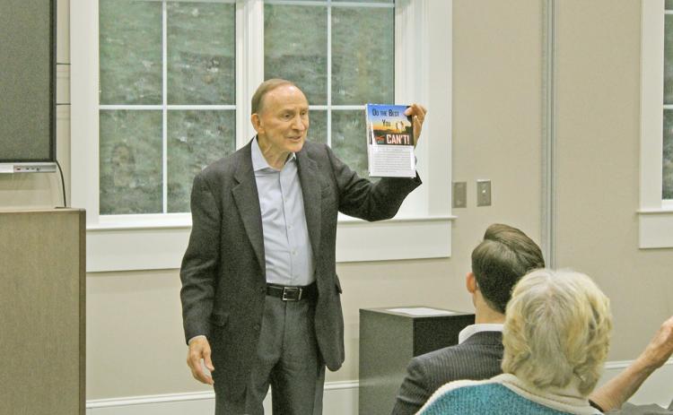 Senator Bud Stumbaugh holds up a copy of his inspirational book "Do the Best You Can’t!" during an Authors in the Afternoon event at the Lumpkin County Library. The book is available on Amazon and other online retailers.