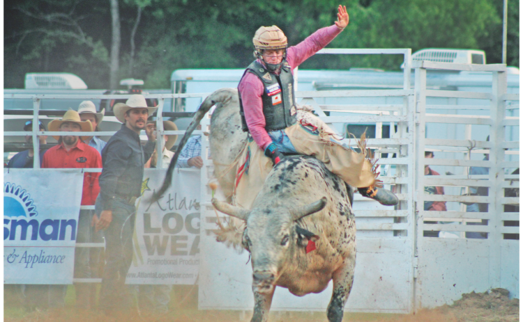 Cole Devlin bravely attempts to stay on the saddle in the bull riding competition during the Mountain Top Rodeo at the R-Ranch.