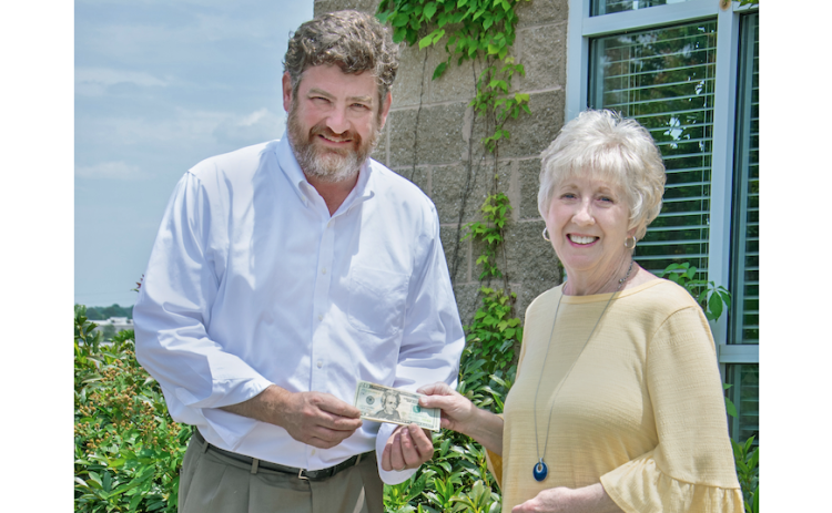 Cornelia resident Donna Shirley receives her $100 prize money from Alan NeSmith, Community Newspapers Inc. chairman. Shirley’s photograph of the double waterfalls that make up Anna Ruby Falls graces the cover of the 2023 summer edition of The Mountain Traveler magazine. (Photo/Kimberly Brown)