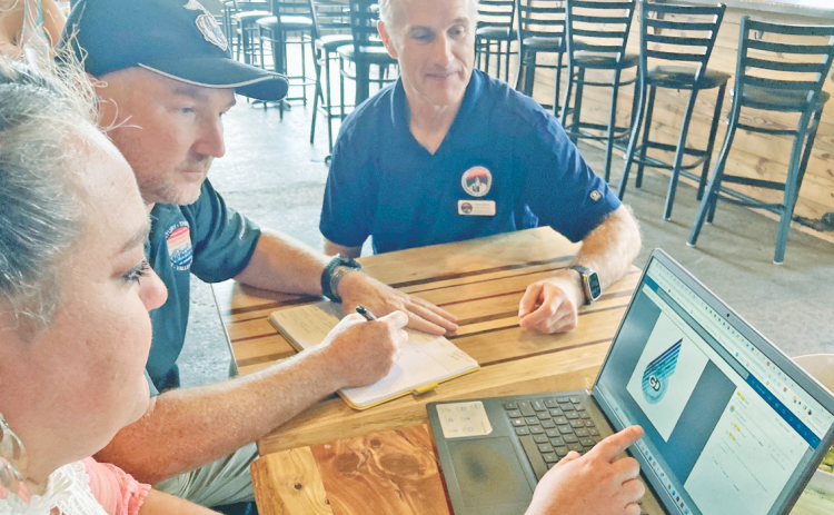 Members of the Six Gap Organizing Committee, from left, Mea Inglehart, Joe Coddington and Robb Nichols work on the new logo for their 6G2 Gravel Ride. They hope to expand the Six Gap brand to include five races throughout the year.