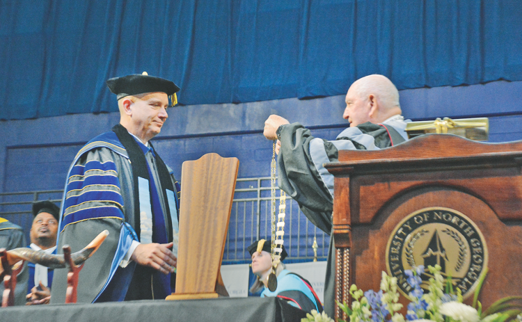 Sonny Perdue, the University System of Georgia Chancellor, performs the investiture of Michael Shannon while the audience looks on at the UNG convocation center.  During his inaugural address, Shannon reminded the audience of his goal to make UNG the most innovative, dynamic legacy making institution in the country. “College changes everything,” he said. “We will teach every student how to think, not what to think.”
