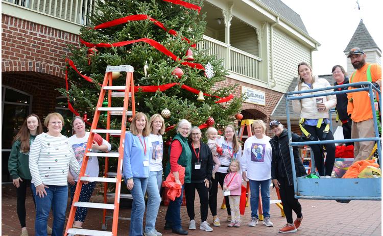 Volunteers from the Old Fashioned Christmas Committee helped City employees to decorate the Christmas tree in front of the Visitors Center last week in preparation for a month of holiday celebrations in downtown Dahlonega. (Photo by John Bynum)