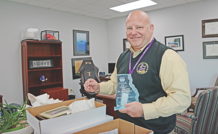 Dr. Rob Brown carefully packs his keepsakes in preparation for his retirement as Lumpkin’s superintendent.