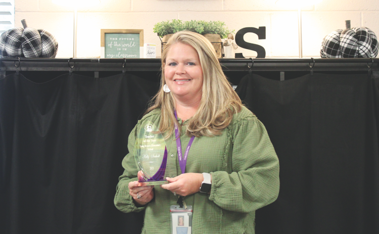 Kelly Seabolt displays her 2025 Teacher of the Year award for Long Branch Elementary.