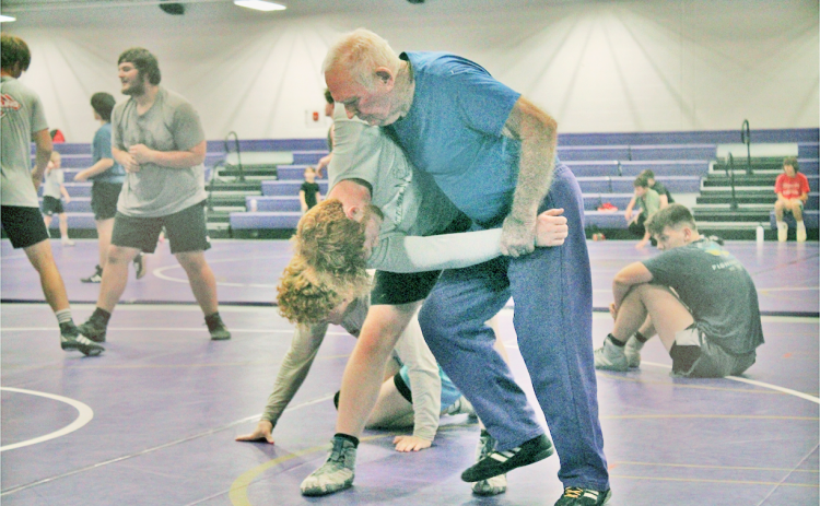 Ed Wright assists Jacob Pricer during one of the team’s practices.
